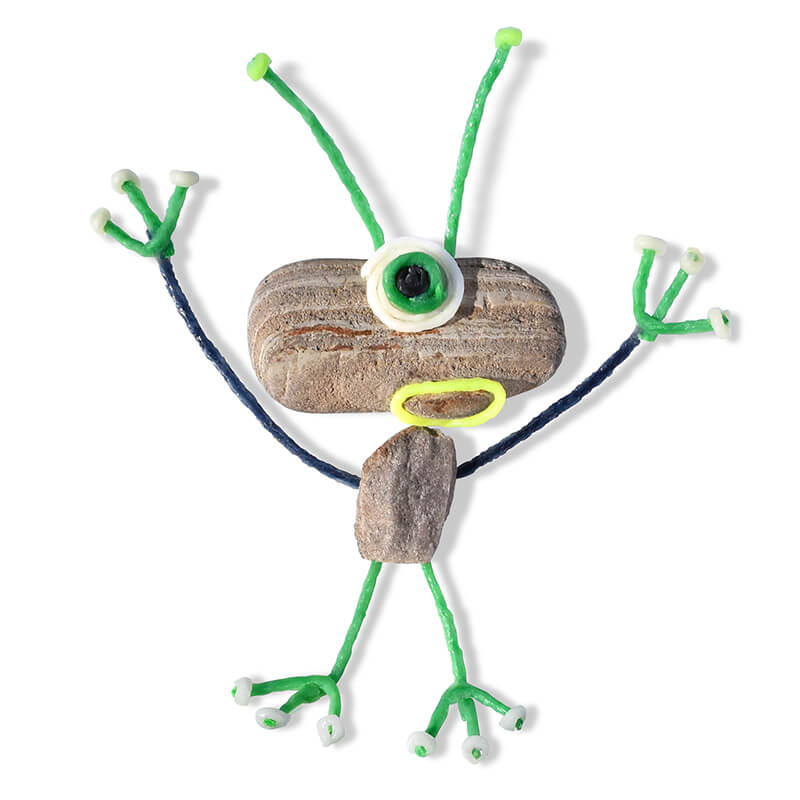 Two rocks decorated with Wikki Stix to create an alien.