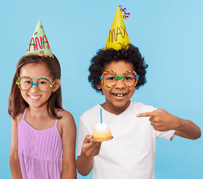 A girl and boy having fun with their Birthday Hats with their name created with Wikki Stix.