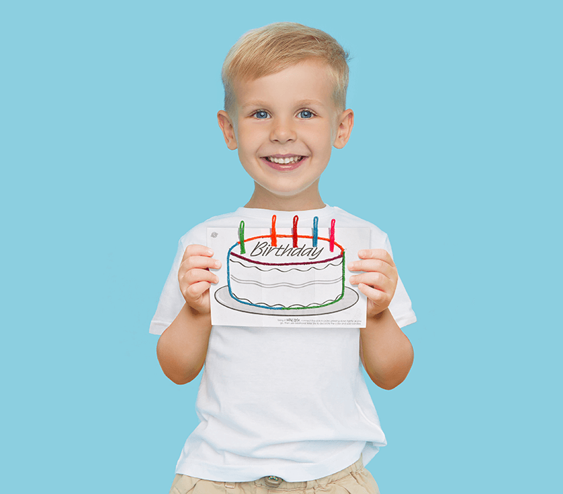 Boy holding a completed Wikki Stix birthday cake playsheet.