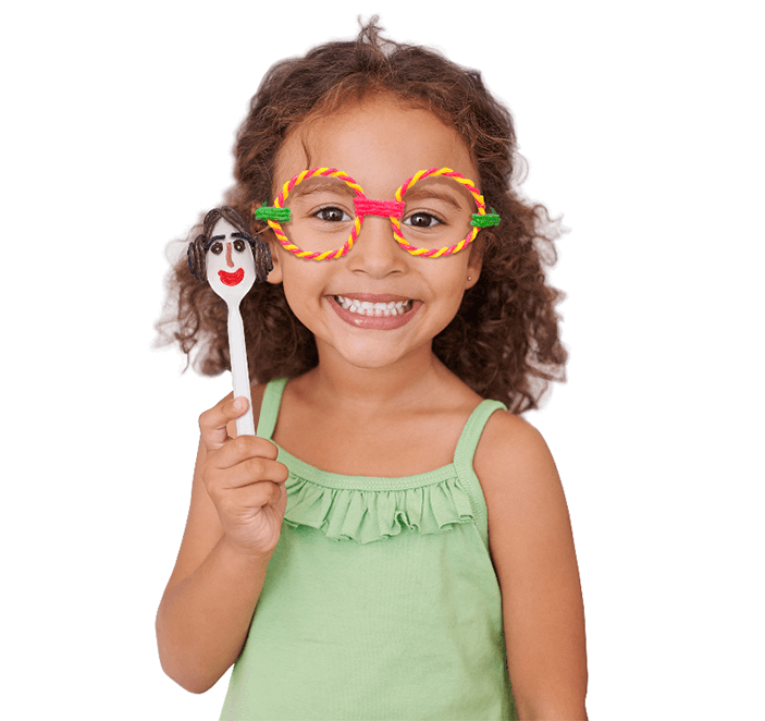 Adorable girl wearing Wikki glasses and holding a Star Wars spoon craft created with Wikki Stix.